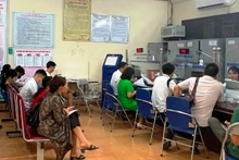 Người dân xếp hàng làm thủ tục hành chính tại huyện Thanh Trì. 