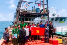 Tổ công tác tuyên truyền kết hợp tặng cờ tổ quốc cho ngư dân.