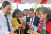 Thứ trưởng Bộ Công thương Phan Thị Thắng (áo vàng) và Lãnh đạo tỉnh Long An tham quan sản phẩm của doanh nghiệp trưng bày tại hội nghị.