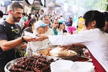 Du khách nước ngoài thưởng thức món ngon của Việt Nam.