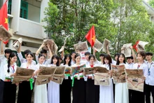 Các em học sinh Trường trung học phổ thông Công nghiệp Hòa Bình vui mừng đón nhận phụ san Báo Nhân Dân. (Ảnh: NGUYỄN TUẤN)