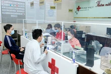 Bệnh nhân và người nhà làm thủ tục thanh toán bảo hiểm y tế tại Bệnh viện Ung bướu Hưng Việt, Hà Nội. (Ảnh NGUYỄN ĐĂNG)
