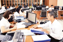 Cán bộ Trung tâm hành chính công tỉnh Thái Bình hỗ trợ người dân giải quyết thủ tục hành chính. (Ảnh THẾ DUYỆT) 