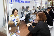 Người dân giao dịch tại Chi cục Thuế quận Tây Hồ, Hà Nội. (Ảnh NGUYỄN QUANG)