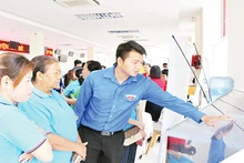 Đoàn viên, thanh niên hướng dẫn người dân thực hiện giao dịch hành chính qua nền tảng công nghệ tại UBND huyện Nhà Bè. (Ảnh THẾ ANH)