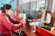 Công chức Trung tâm phục vụ hành chính công tỉnh Kiên Giang giải quyết thủ tục hành chính cho người dân. (Ảnh: QUỐC TRINH)
