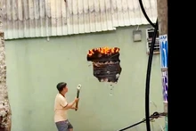 Lực lượng tham gia chữa cháy đập tường để tiến hành chữa cháy.
