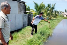 Ông Đặng Văn Đa (bên phải) chỉ nơi 2 cháu nội bị đuối nước tử vong.