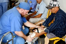 Thành viên Đoàn thiện nguyện Mercer On Mission lắp chân giả cho người khuyết tật.