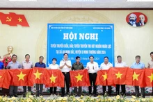 Ban tổ chức tặng cờ Tổ quốc cho ngư dân và bí thư chi bộ, cựu chiến binh xã An Minh Bắc, huyện U Minh Thượng, tỉnh Kiên Giang.