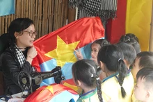 Các em nhỏ tìm hiểu về cờ giải phóng tại buổi khai mạc triển lãm. (Ảnh: MẠNH HẢO)