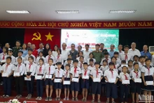 Nguyên lãnh đạo Trung ương, lãnh đạo địa phương và nhà tài trợ chụp hình với cho học sinh dân tộc thiểu số, học sinh nghèo khu vực biên giới tỉnh Long An.