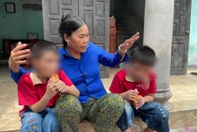 Bà Cúc và 2 người con không chung huyết thống Bảo Q., Bảo K. bên hiên nhà. 