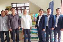 Đại diện lãnh đạo Công ty 705/Quân khu 2 bàn giao 10 tấn thóc giống cho chính quyền tỉnh Oudomxay (Lào). (Ảnh: Hải Tiến)