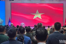 Các đại biểu chào cờ tại Lễ kỷ niệm. (Ảnh: TRỊNH DŨNG)