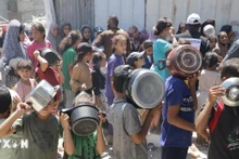 Trẻ em xếp hàng nhận thức ăn cứu trợ tại trại tị nạn Jabalia ở Dải Gaza. (Ảnh: THX/TTXVN)