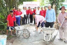 Thành viên Hội Chữ thập đỏ xã Đông Thạnh, thị xã Bình Minh (tỉnh Vĩnh Long) tham gia vá đường giao thông nông thôn. (Ảnh: BÁ DŨNG)