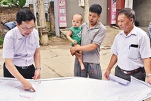 Cán bộ Trung tâm Phát triển quỹ đất huyện Mê Linh khảo sát thực địa công tác giải phóng mặt bằng đường vành đai 4 đoạn qua xóm Trại A, thôn Khuê Ngoại, xã Văn Khê. (Ảnh: DUY LINH)