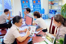 Cán bộ ngành thuế hỗ trợ thủ tục nộp thuế cho hộ kinh doanh tại thành phố Buôn Ma Thuột (tỉnh Đắk Lắk). (Ảnh: KHÁNH HUYỀN)