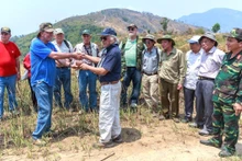 Cựu chiến binh Mỹ John Cimino trao lại chiếc ví kỷ vật của liệt sĩ Hoàng Quang Lợi cho Ban liên lạc tìm đồng đội Trung đoàn 209. (Ảnh: TRƯƠNG ĐỨC BÌNH)