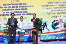 Đại diện lãnh đạo Ủy ban nhân dân tỉnh Quảng Bình trao bảng tượng trưng các công trình dân sinh tặng cụm bản Lẳng Khăng (Lào).