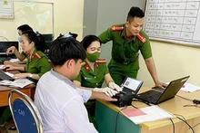 Cán bộ Công an thành phố Yên Bái, tỉnh Yên Bái hướng dẫn người dân đăng ký tài khoản định danh điện tử cấp độ 2 và phòng ngừa các thủ đoạn của tội phạm công nghệ cao. (Ảnh: THANH SƠN)