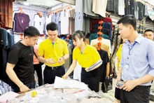 Nhân viên ngân hàng hướng dẫn hộ kinh doanh tại chợ Móng Cái thanh toán không dùng tiền mặt.