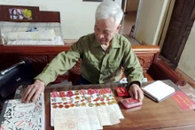 Ông Phạm Văn Ðắc xem lại những kỷ vật thời chiến.