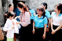 Lãnh đạo Hội Liên hiệp Phụ nữ tỉnh Thanh Hóa và các "Mẹ đỡ đầu" tặng quà cho trẻ mồ côi. (Ảnh THÚY YÊN)