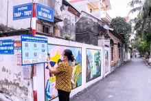 Người dân xã Song Phượng (huyện Ðan Phượng) quét mã QR tìm hiểu thủ tục hành chính. (Ảnh THẮNG VĂN)
