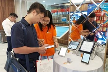 Bạn đọc trải nghiệm một số thiết bị điện tử chuyên dùng để đọc sách. (Ảnh MINH THU)