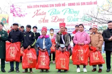 Ðại diện lãnh đạo Bộ đội Biên phòng tỉnh Lai Châu và huyện Phong Thổ trao quà tặng các hộ nghèo ở bản Chí Sáng, xã Sin Suối Hồ, huyện Phong Thổ. (Ảnh ÐỨC DUẨN)