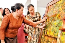 Nghệ nhân làng nghề sơn mài của Hà Nội giới thiệu sản phẩm tới Ðoàn công tác của Sở Công thương Viêng Chăn (Lào).
