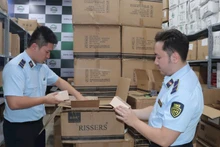 Lực lượng quản lý thị trường tỉnh Lạng Sơn hướng dẫn các hộ kinh doanh chấp hành quy định pháp luật trong kinh doanh, buôn bán. (Ảnh: LƯU QUYÊN)