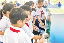 Các em học sinh phân loại rác trước khi bỏ vào xe.