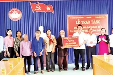 Đại diện Báo Nhân Dân trao bảng tượng trưng số tiền 250 triệu đồng tặng 5 gia đình ở huyện M’Drắk xây nhà Đại đoàn kết.