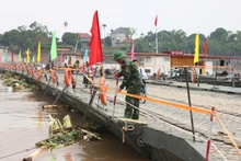 Nước từ thượng nguồn đổ về kéo theo nhiều cây cối khiến cầu phao phải đóng để bảo đảm an toàn.