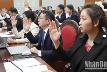 Các đại biểu biểu quyết thông qua các nghị quyết tại kỳ họp thứ 10.