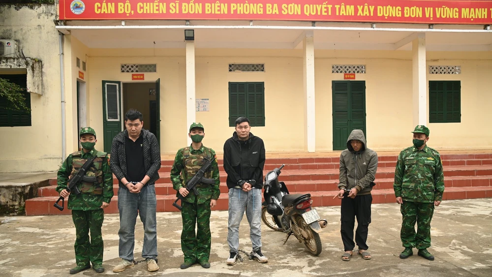 Đối tượng Triệu Văn Hình (đứng thứ 5 từ trái sang phải) và 2 đối tượng người Trung Quốc bị bắt giữ tại Đồn Biên phòng Ba Sơn.