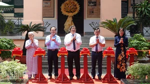 Các đại biểu thực hiện nghi thức cắt băng khai mạc trưng bày. (Ảnh: MẠNH HẢO)