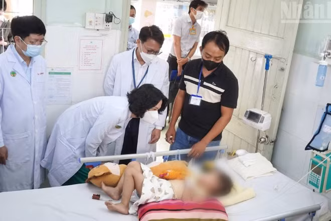 Đoàn công tác của Bộ Y tế thăm bệnh nhi điều trị tay chân miệng tại Bệnh viện Nhi đồng 2. (Ảnh: KHANG ANH)