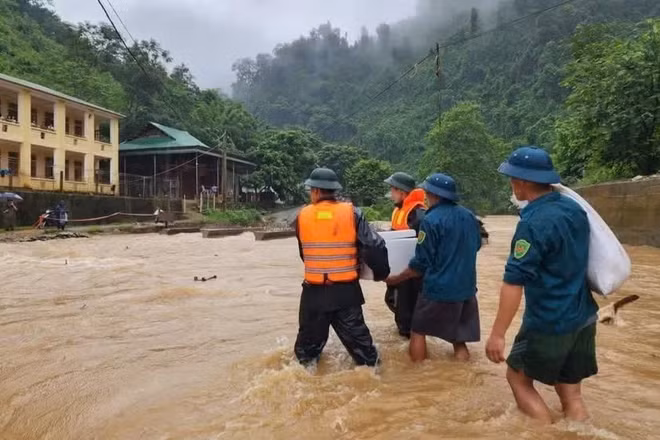 Cán bộ, chiến sĩ Đồn Biên phòng Tam Hợp và Ban Chỉ huy quân sự xã Tam Thái, tỉnh Nghệ An, đưa cơm cho học sinh điểm trường bán trú bị mưa lũ chia cắt. (Ảnh: TRUNG HIẾU) 