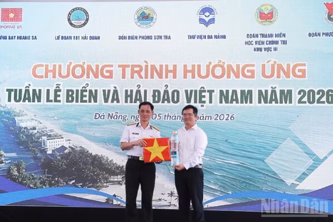 Thượng tá Nguyễn Công Khương, Phó Lữ đoàn trưởng, Lữ đoàn 161 trao tặng mẫu nước biển lấy từ vùng biển Hoàng Sa cùng cờ Tổ quốc của các tàu thực hiện nhiệm vụ trên biển.