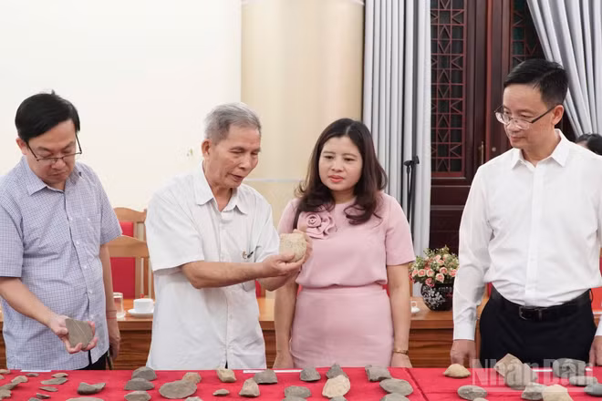 Các nhà nghiên cứu giới thiệu di chỉ khảo cổ với lãnh đạo tỉnh. (Ảnh: THANH SƠN)