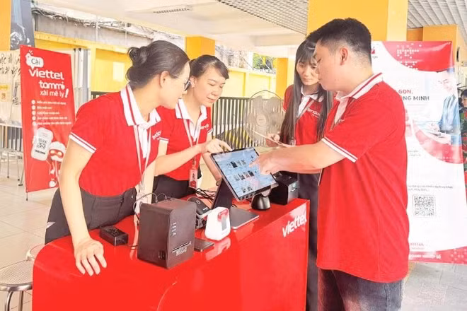 Đại diện Viettel thực hiện thao tác hướng dẫn người dân sử dụng các công cụ chuyển đổi số trong quản lý, kinh doanh ở quy mô hộ gia đình.