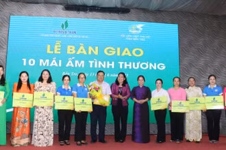 Đại diện Báo Nhân Dân trao bảng tượng trưng bàn giao 10 căn nhà mái ấm tình thương cho phụ nữ có hoàn cảnh khó khăn trên địa bàn. (Ảnh: HOÀNG TRUNG)