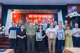 Đại diện các gia đình đón nhận di ảnh anh hùng liệt sĩ tại sự kiện. 