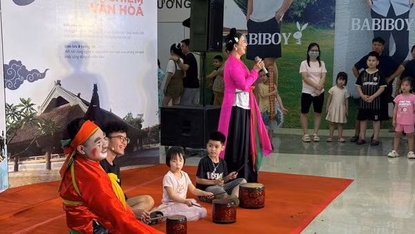 Các em thiếu niên, nhi đồng trải nghiệm nghệ thuật chèo với sự hướng dẫn của nghệ sĩ.