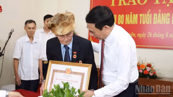 Đại tướng Phan Văn Giang, Ủy viên Bộ Chính trị, Phó Thủ tướng Chính phủ, Bộ trưởng Quốc phòng trao Huy hiệu cho đảng viên lão thành Nguyễn Quang Nam. (Ảnh: DUY ĐỨC)