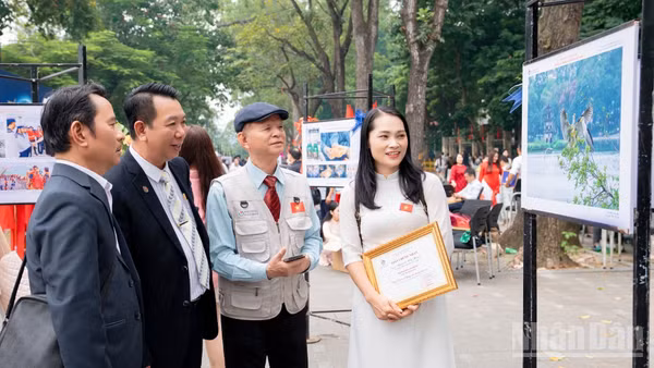 Tại không gian trưng bày, những người làm nhiếp ảnh cùng nhau quan sát, trao đổi về chuyện nghề.